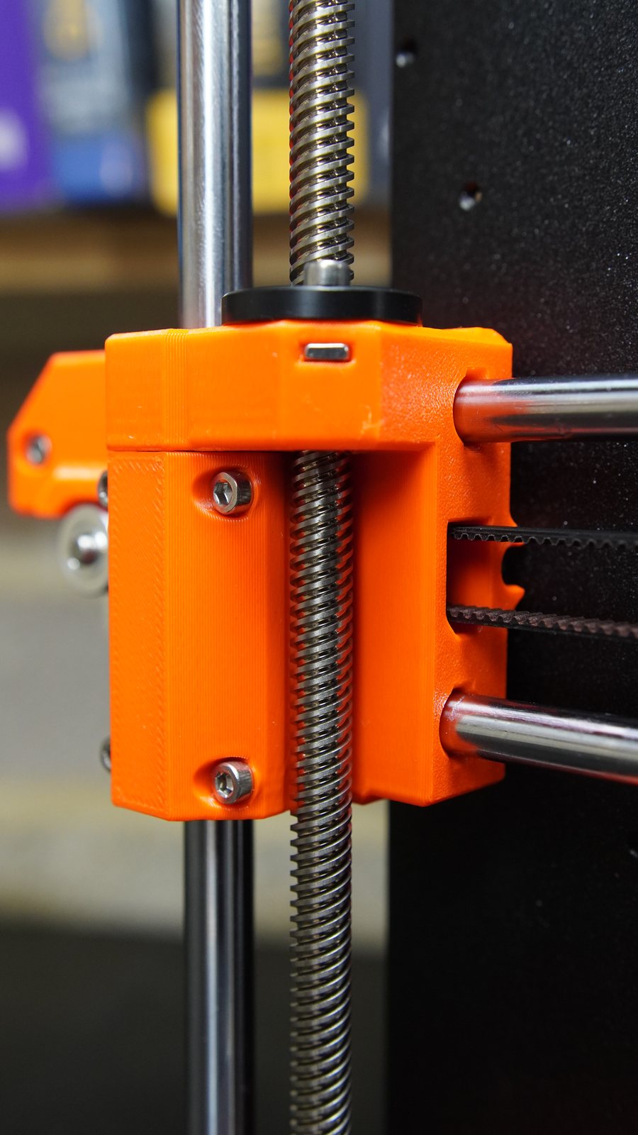 Close-up of the Prusa MK4 Z-axis leadscrew and orange printed part.