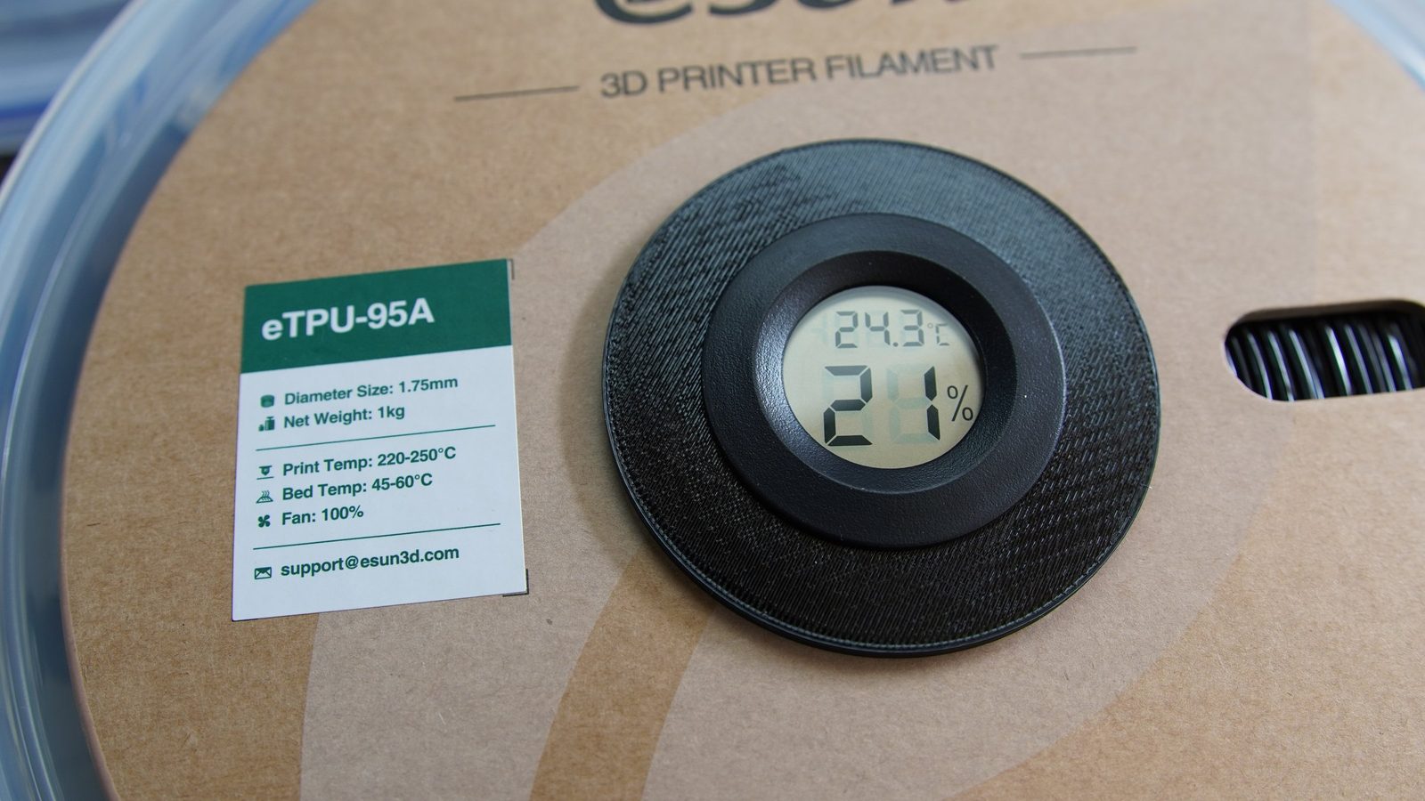 A hygrometer in the hub of an eSun TPU spool reading 24.3 degrees Celsius and 26 percent relative humidity.