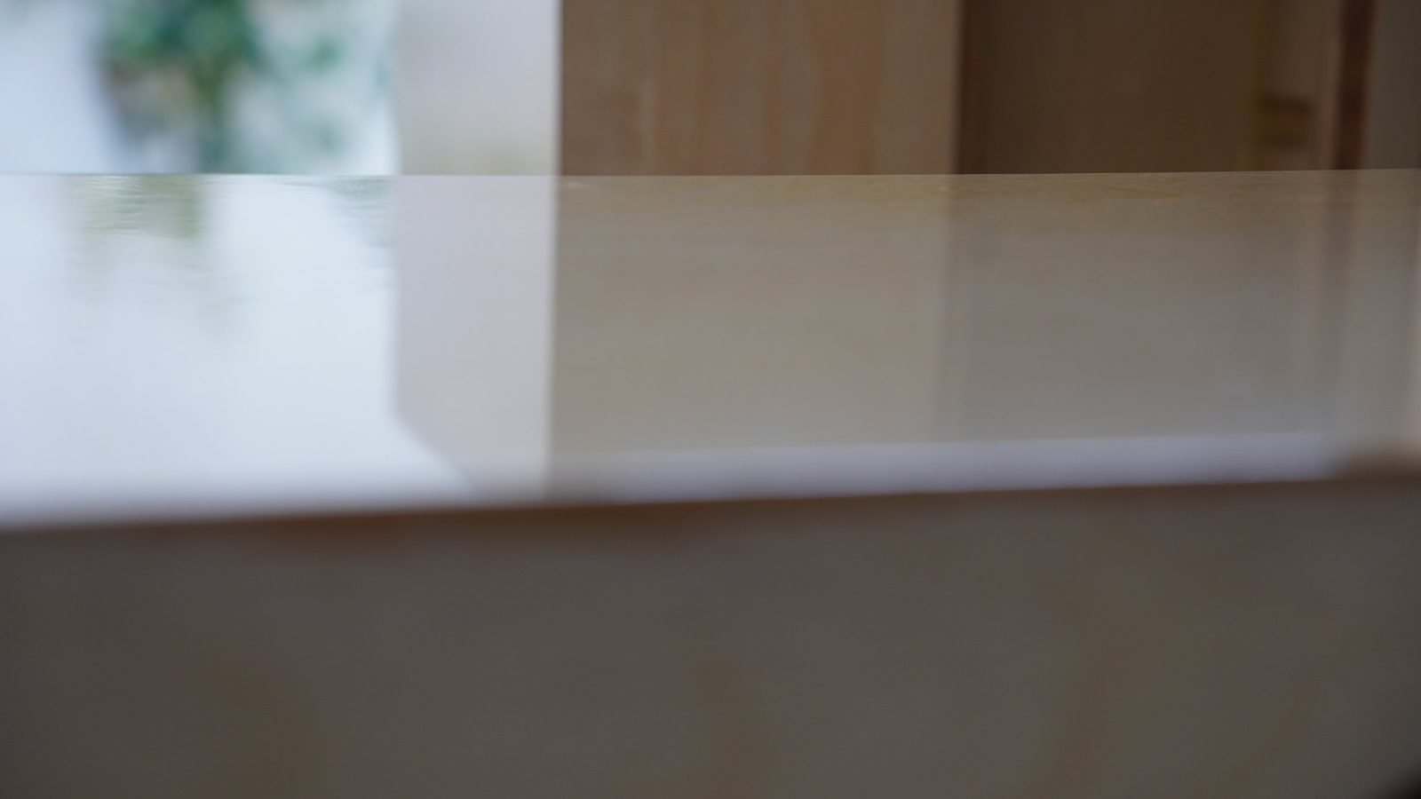 Close view of the glossy clear finish and plywood edge on the speaker cabinet.