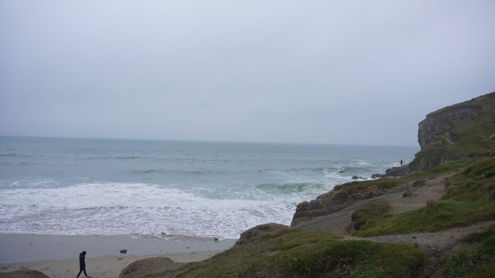 Grey sea, cliffs and surf near the belly board course location.