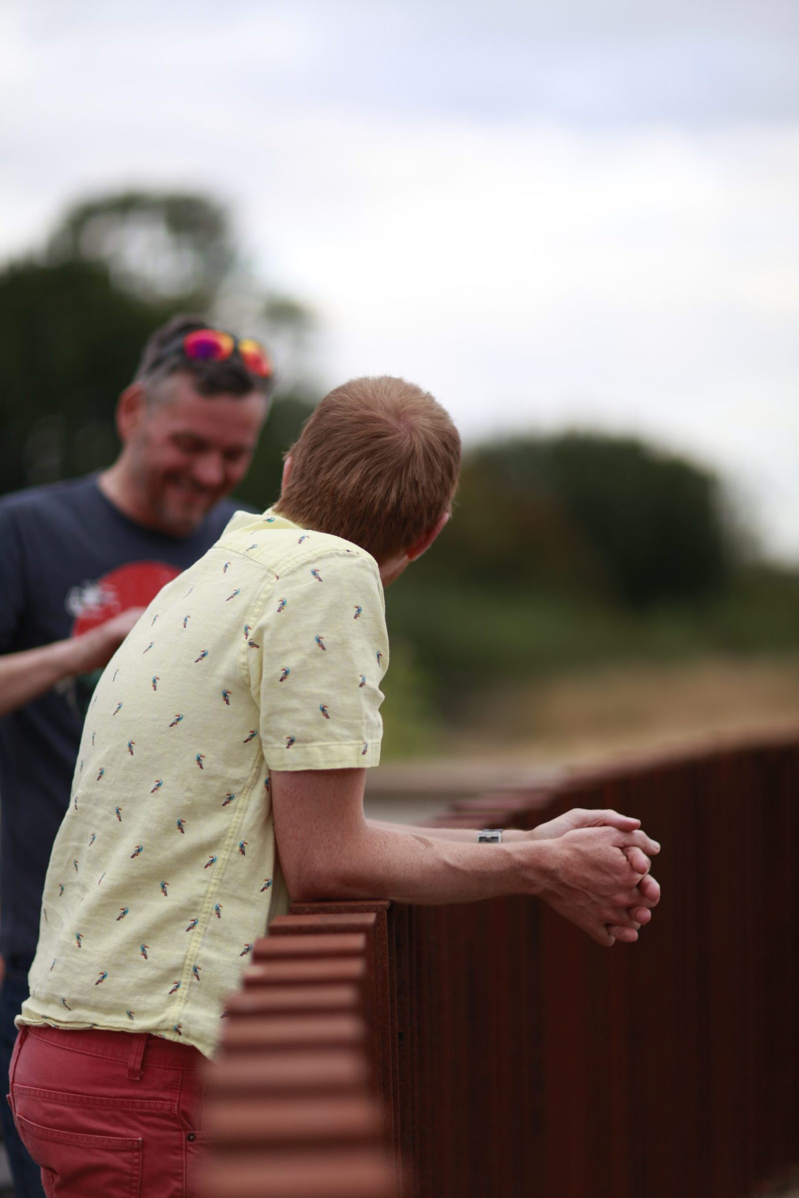 Close view of people leaning on the corten balustrade.