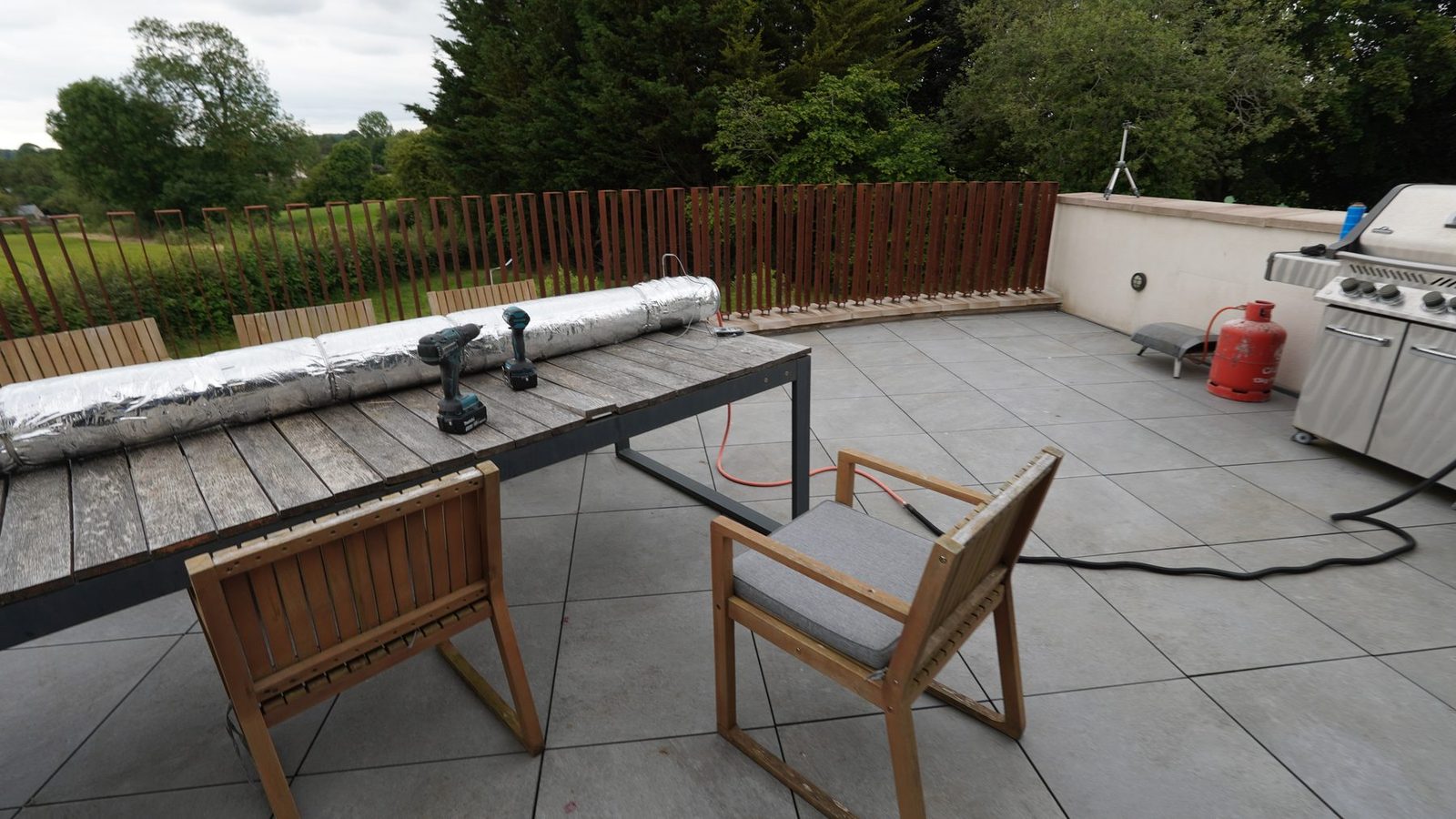 Steam box on a terrace with tools and chairs around it.