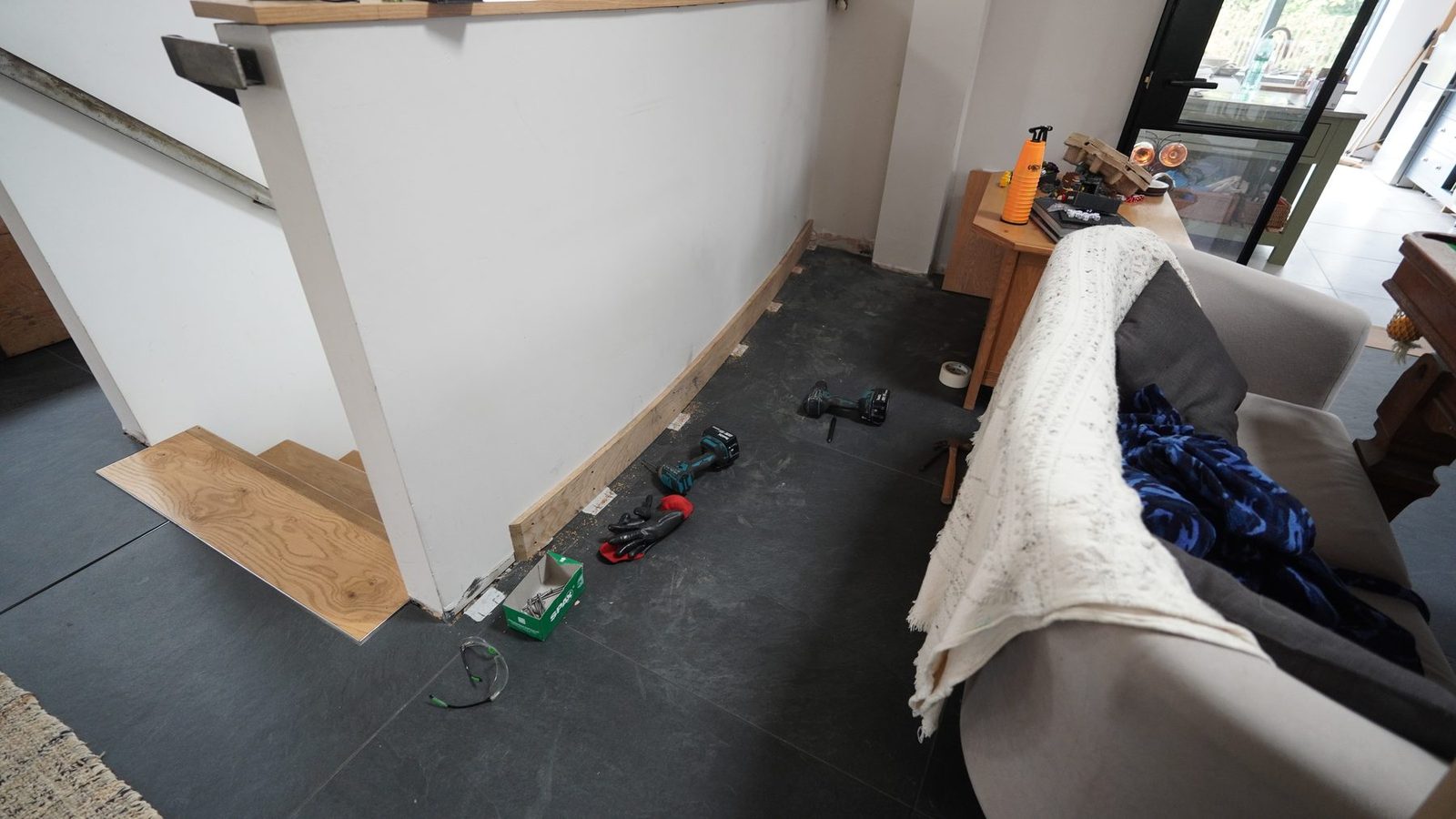 Curved skirting board installed along the wall with tools on the floor.