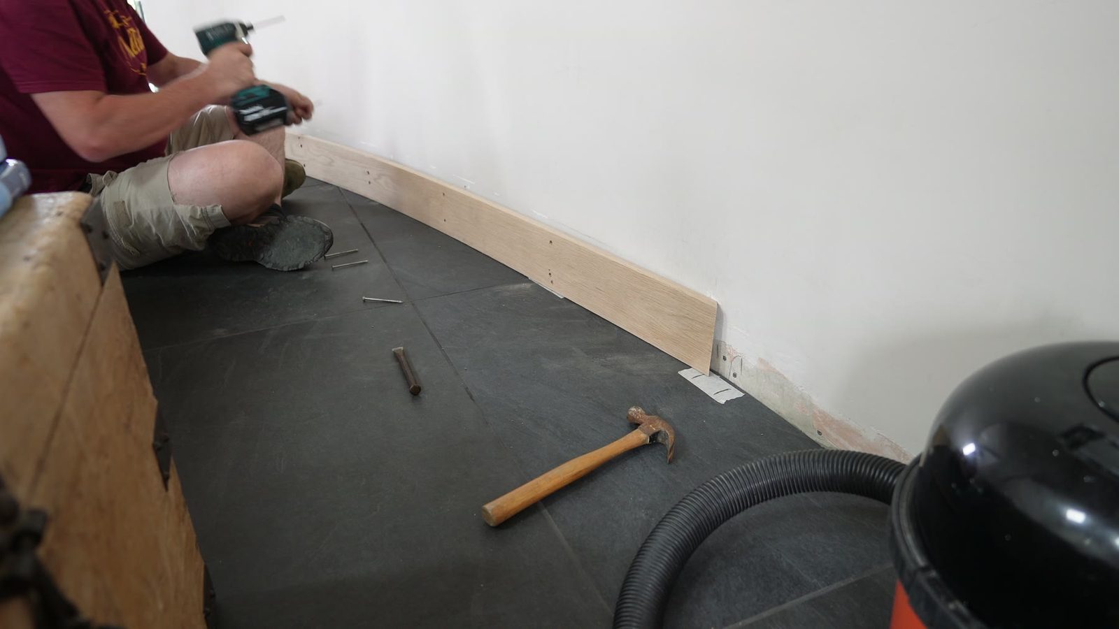 Fixing the curved skirting board to the wall.