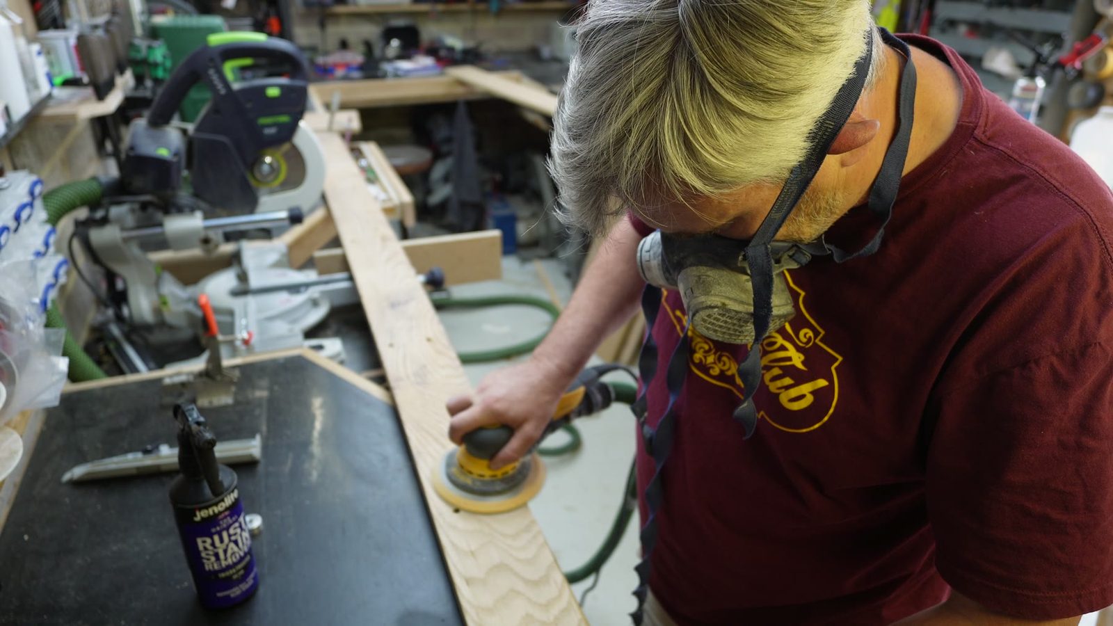 Sanding or finishing the curved skirting board in the workshop.