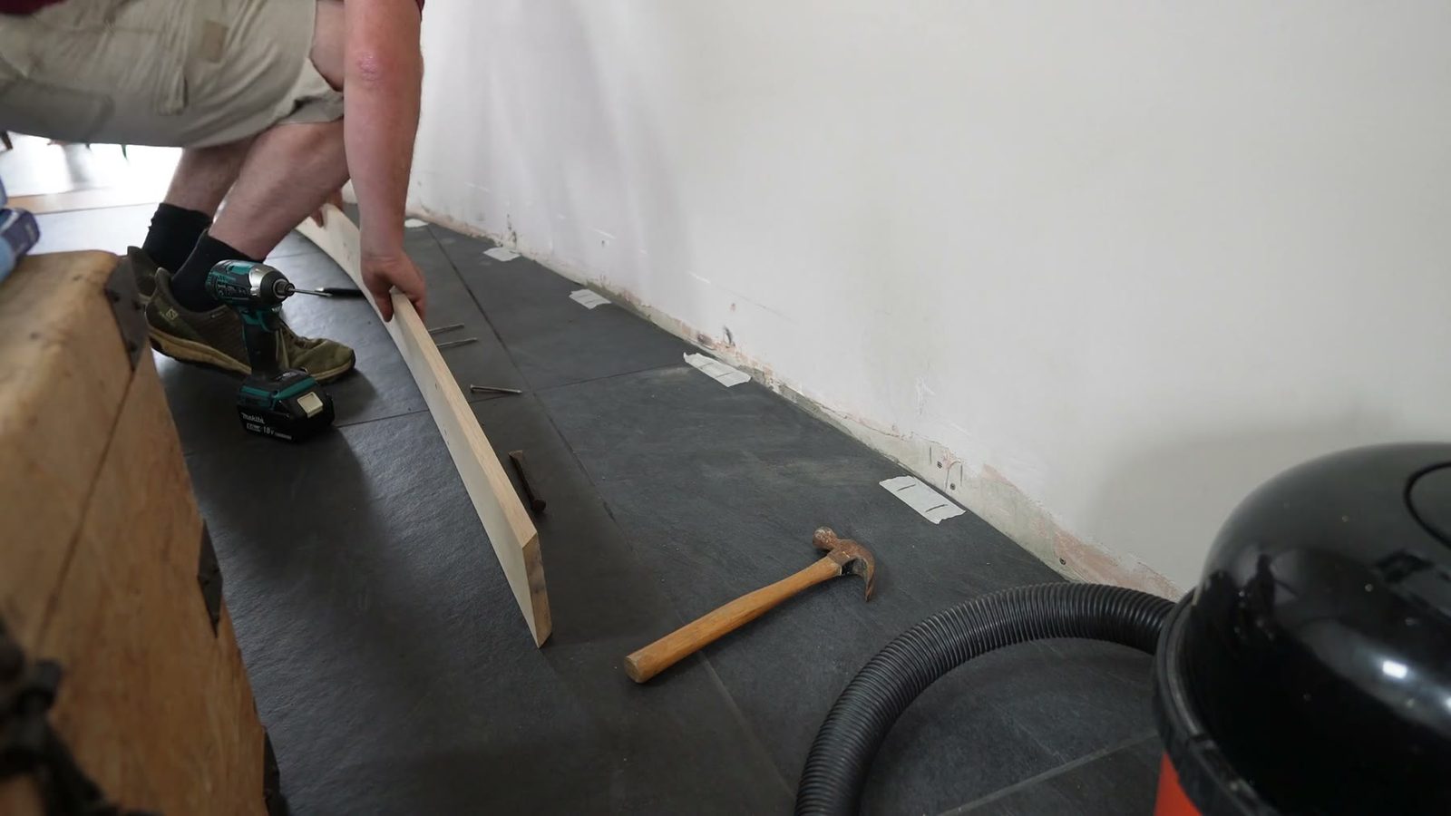 Fixing the curved skirting board into place against the wall.