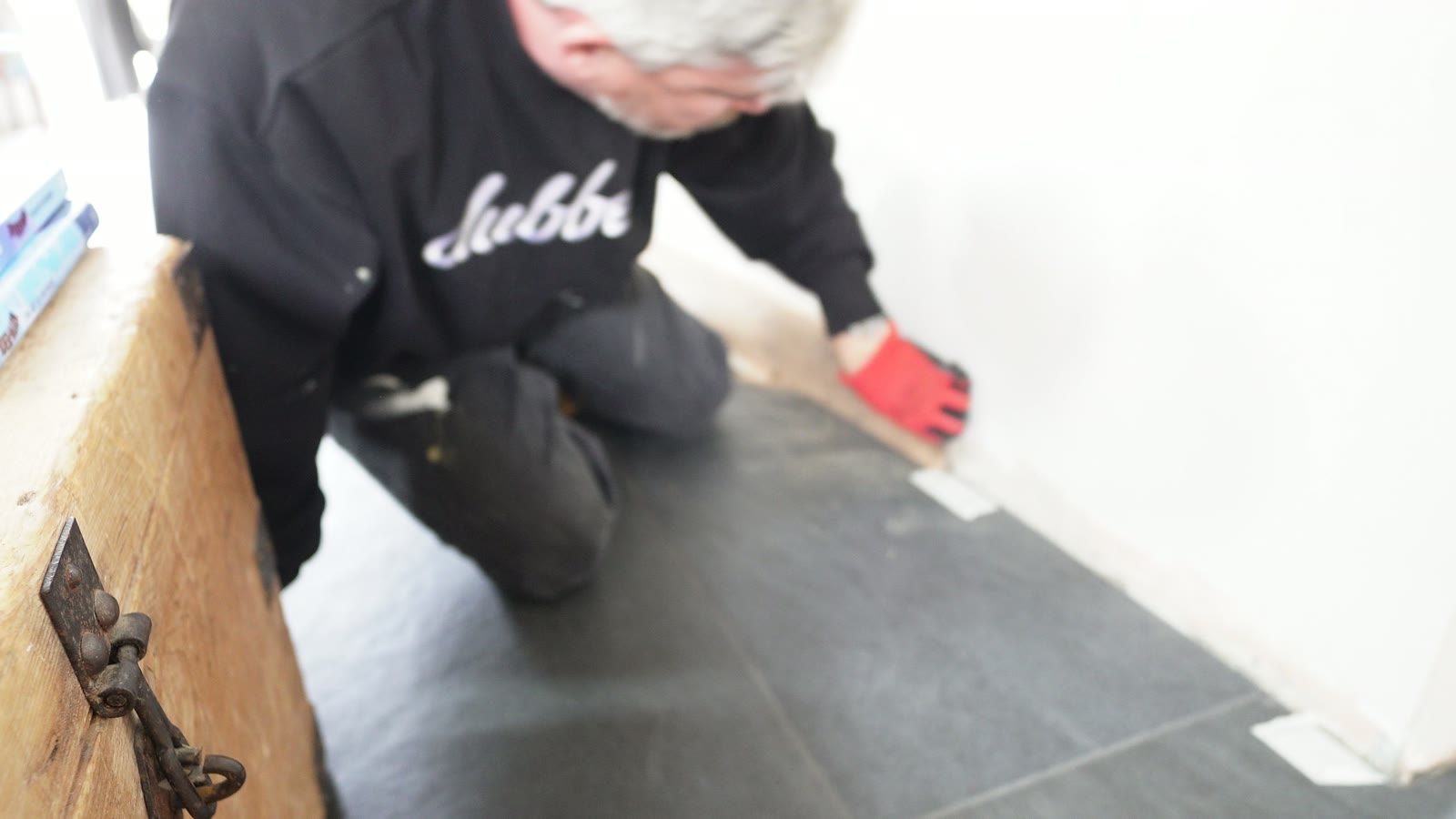 Daniel checking a dark curved skirting board section against the wall.