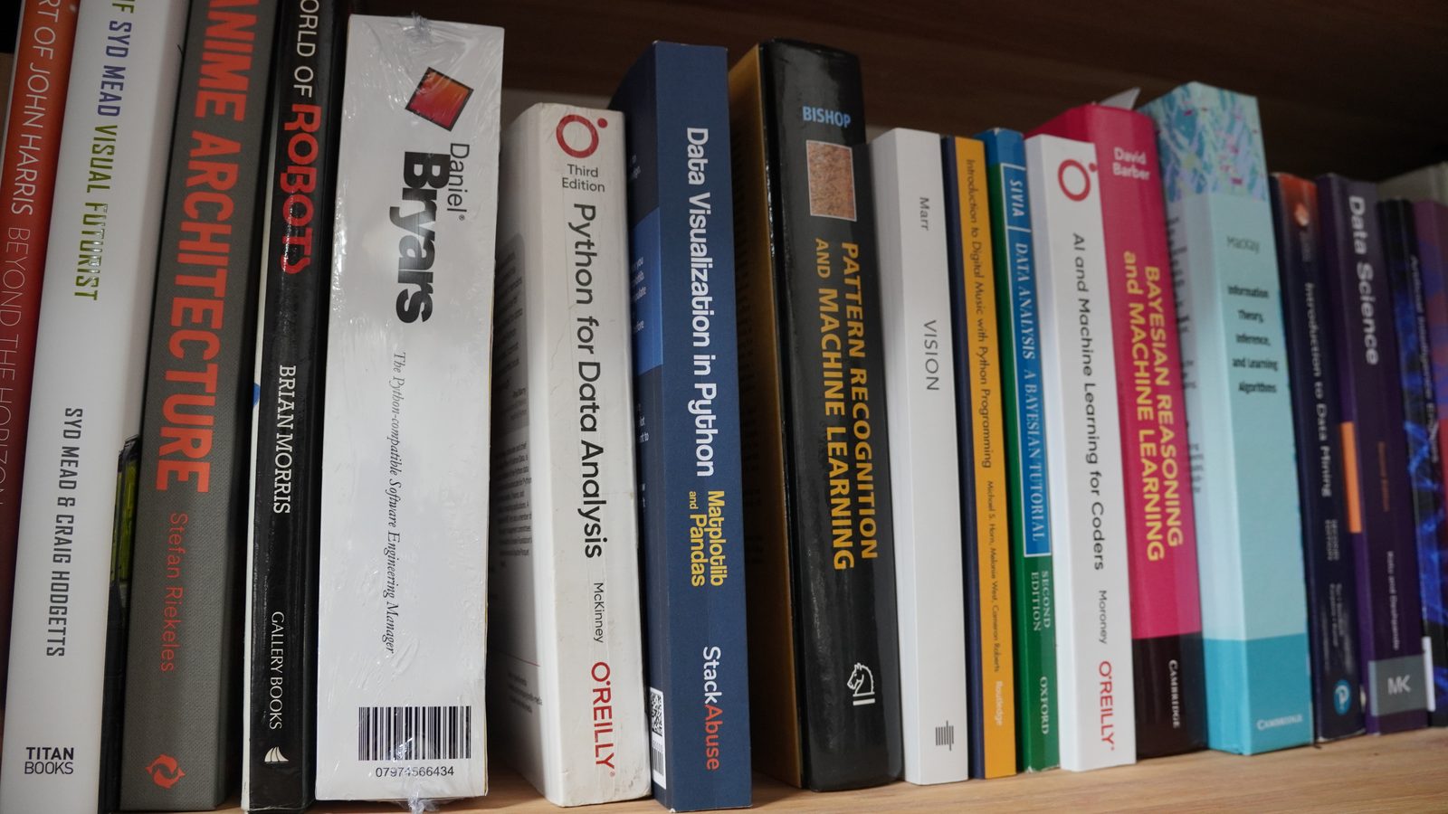 The CV in a Box sitting on a bookshelf between technical books.