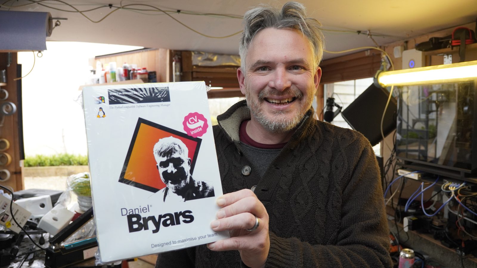 Daniel smiling while holding the CV in a Box in the workshop.