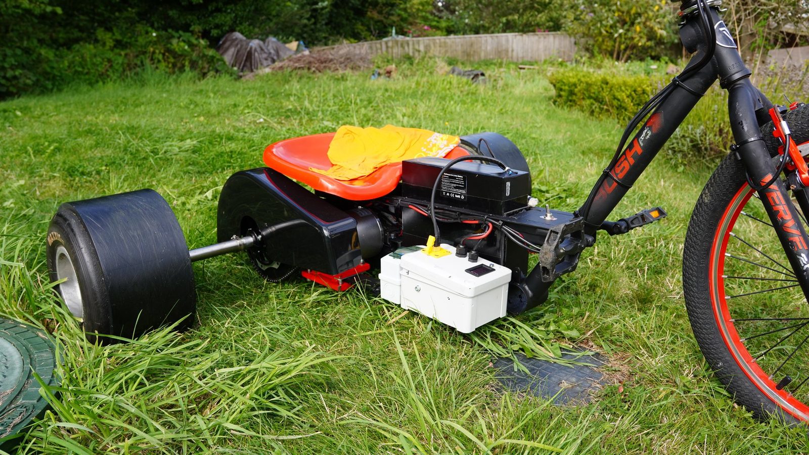 A finished electric drift trike photographed on grass.