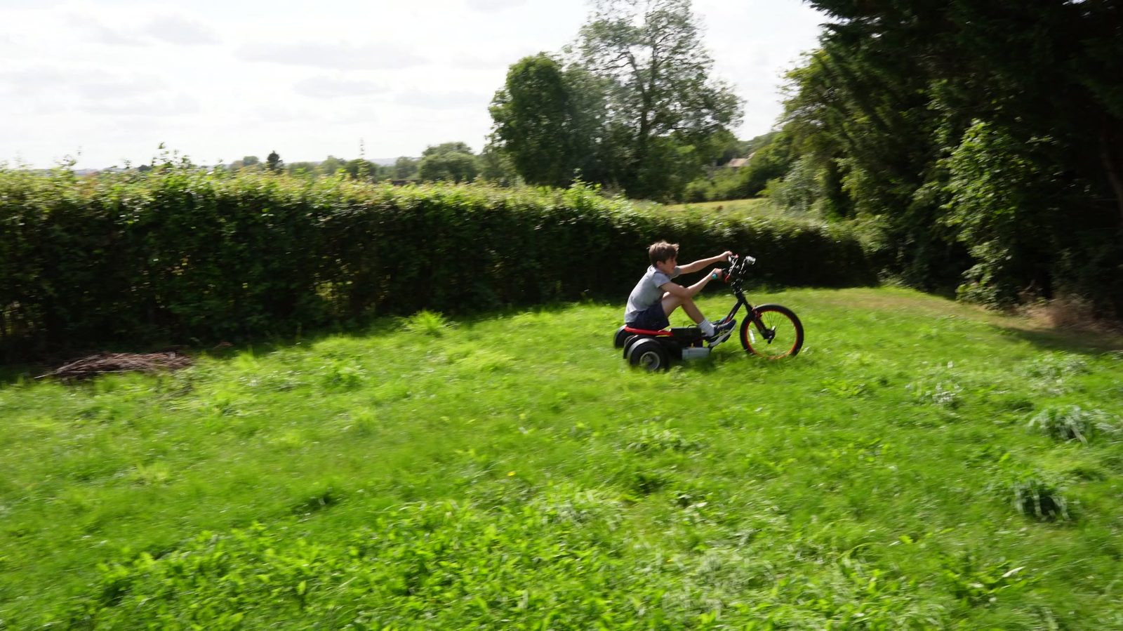 Lincoln driving the finished drift trike on grass.