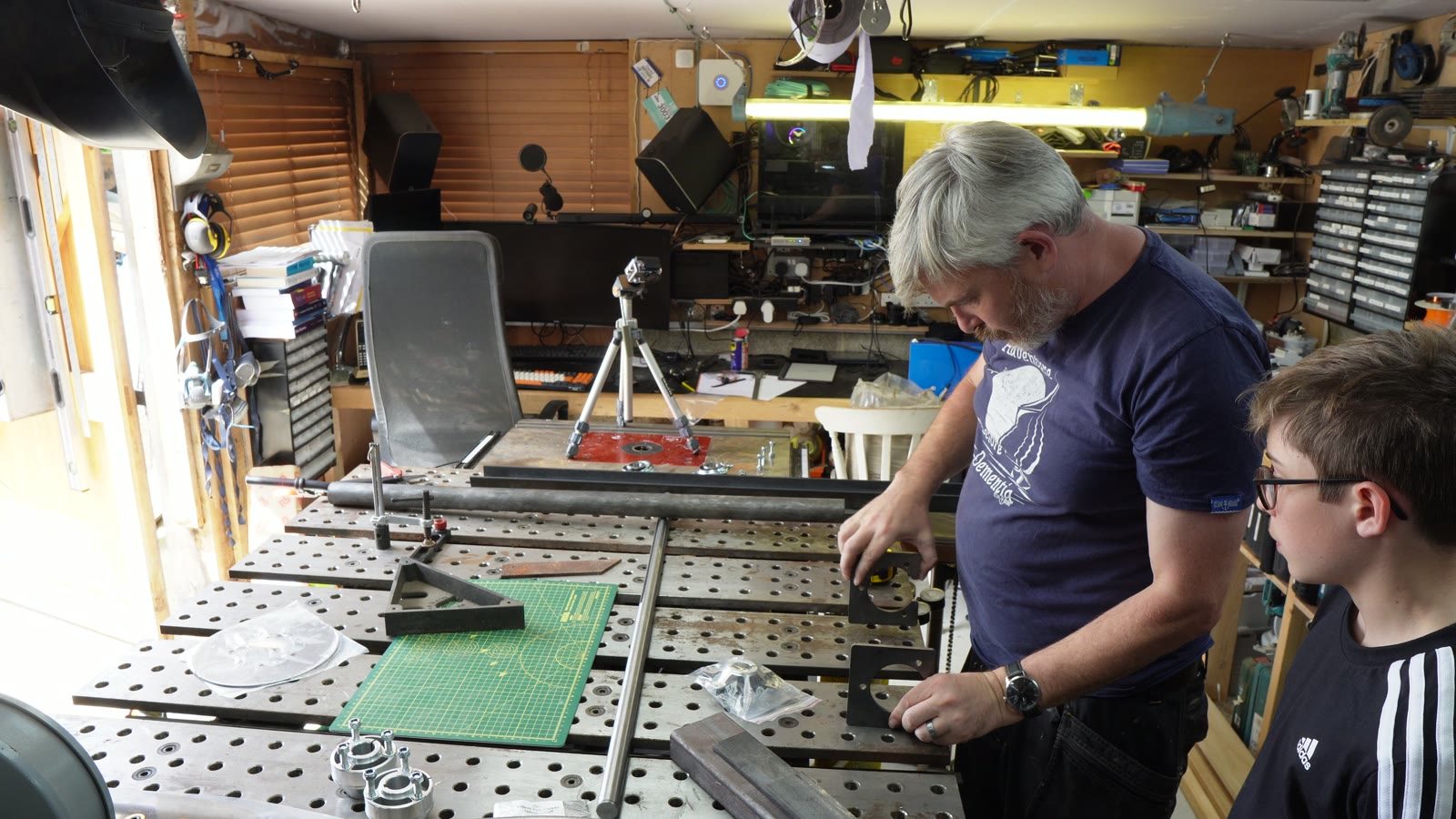 Daniel and Lincoln laying out drift trike frame parts on the welding table.