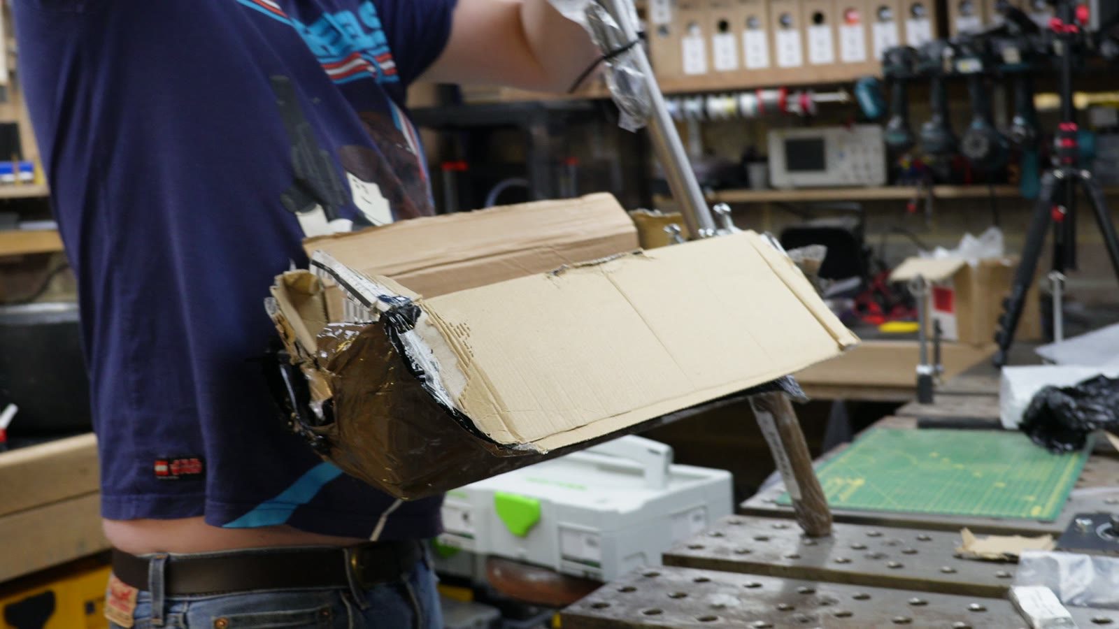 Cardboard packaging and drift trike parts being unpacked on the workbench.