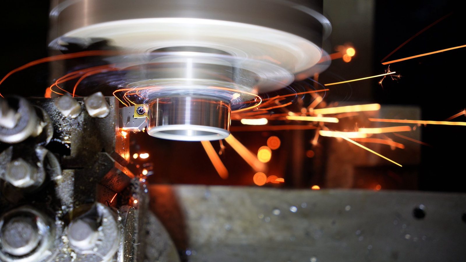 Curled trails of sparks around the spinning workpiece.