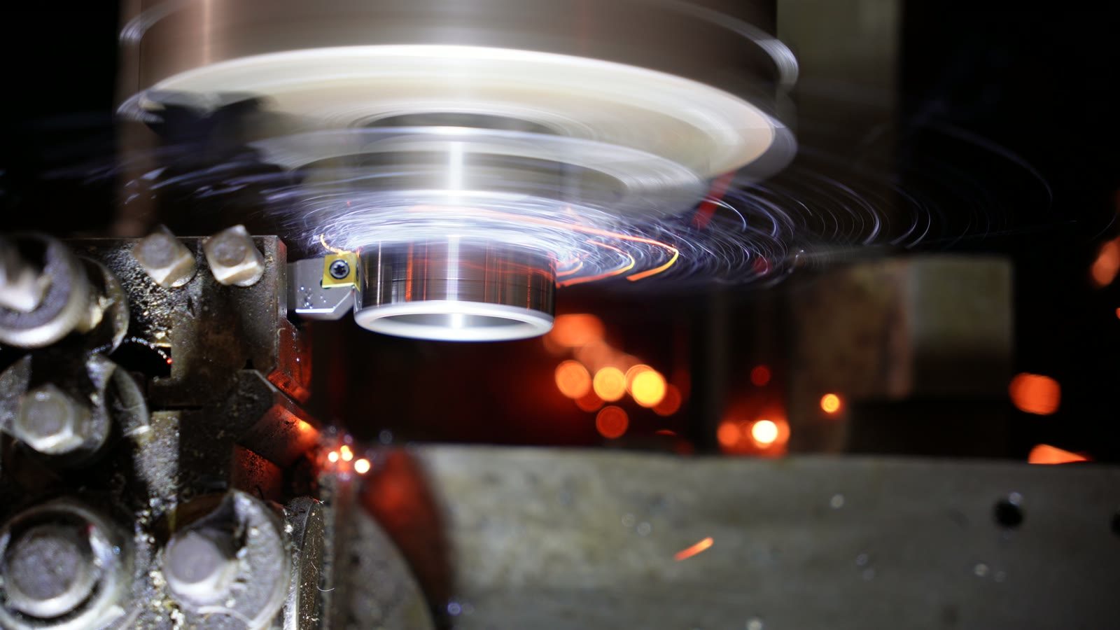 Sparks falling below a spinning metal part on the Colchester Chipmaster.