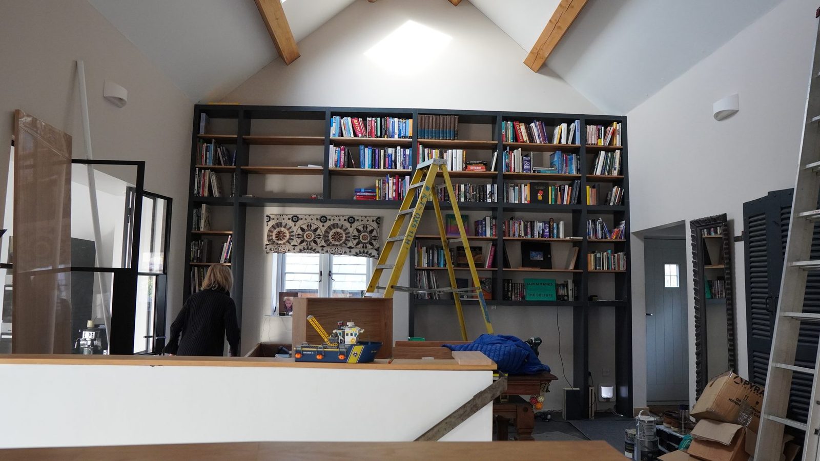 Room-wide view of the bookcase with the ladder installed.