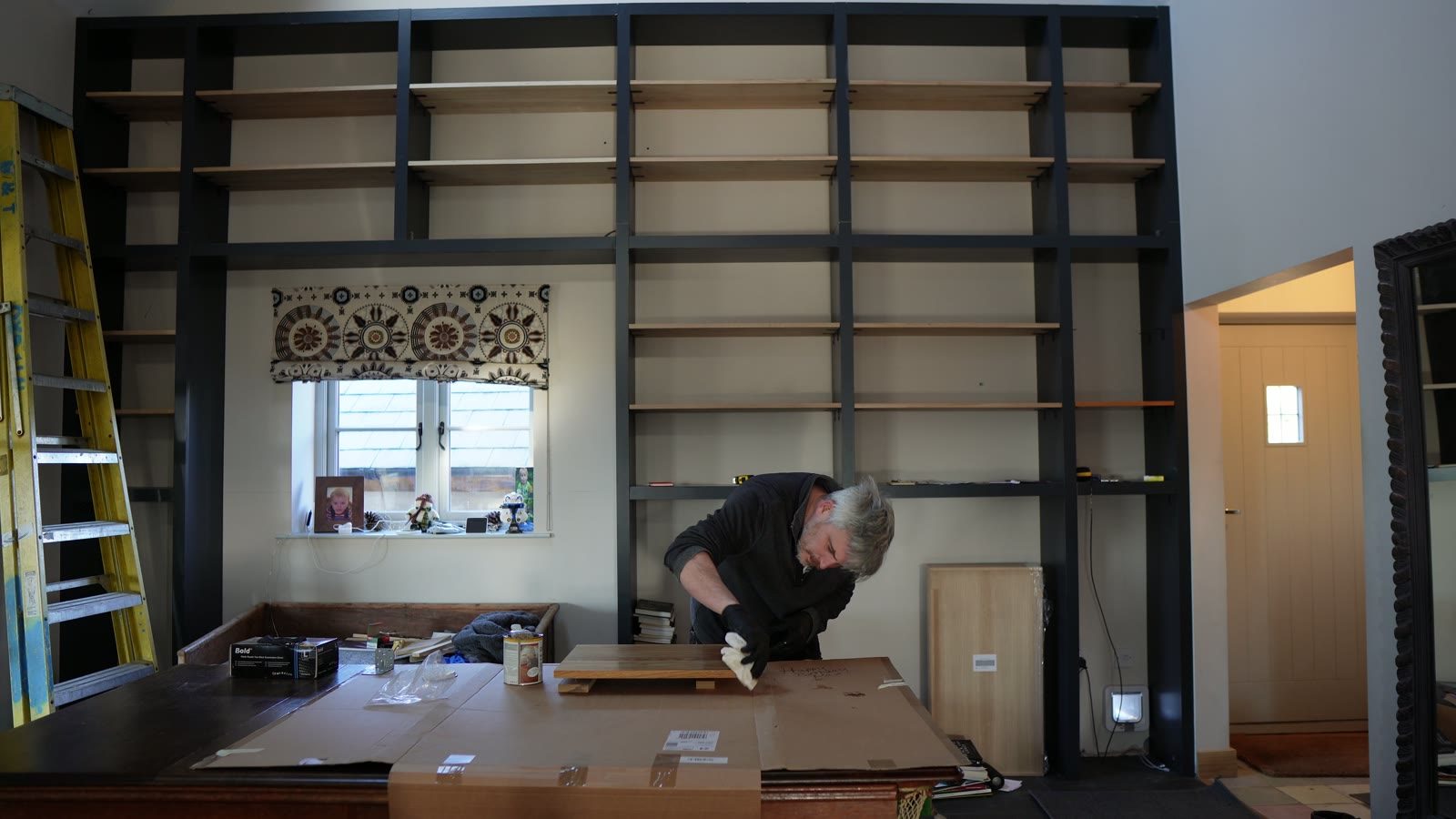 Daniel working at the lower console area beneath the bookcase.