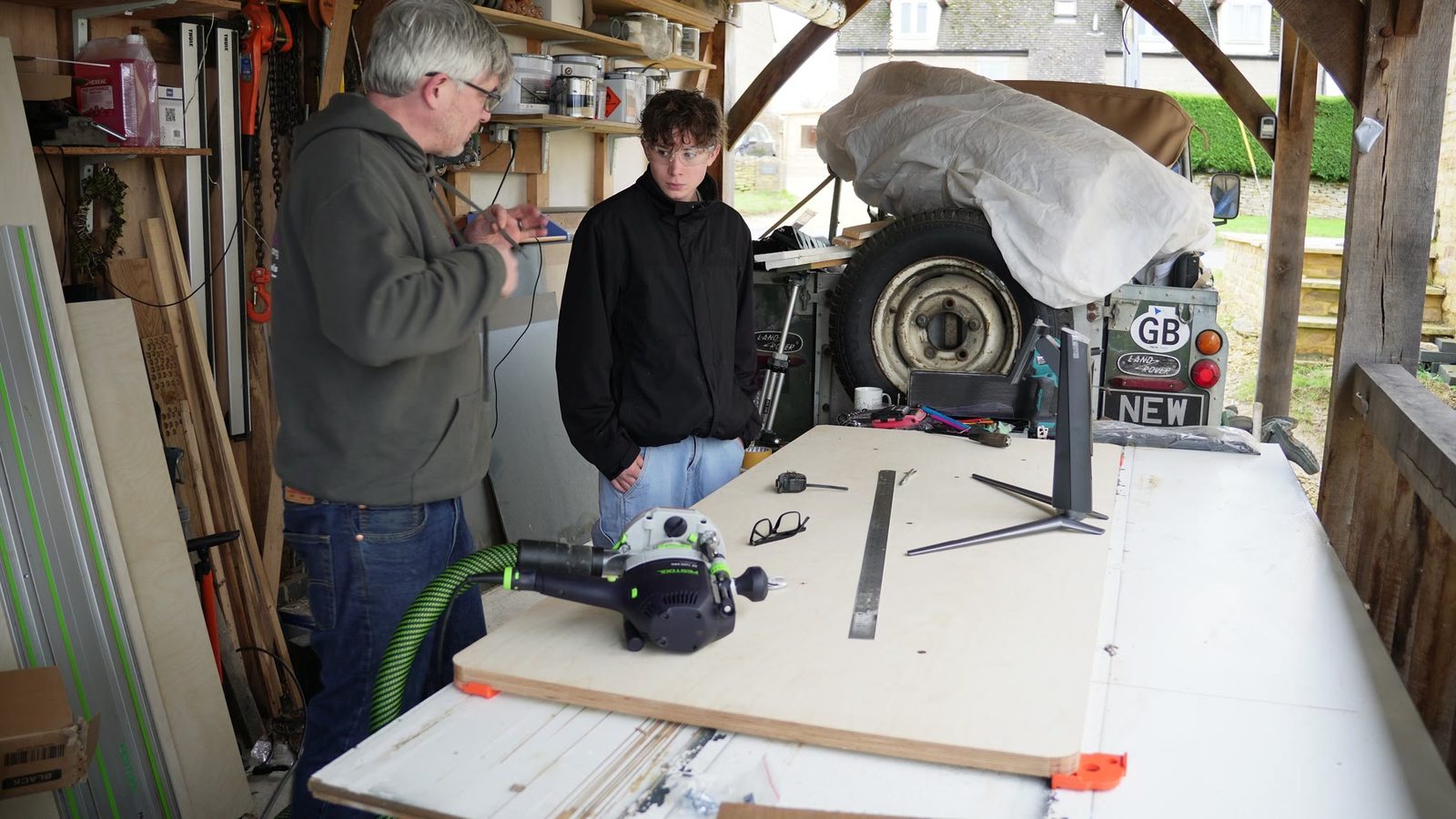 Daniel and his son working around the desk top in the workshop.