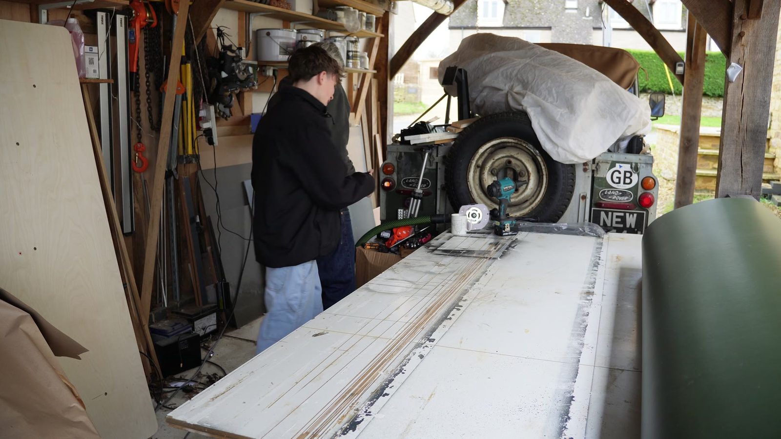 Daniel and his son marking and cutting the desk top.