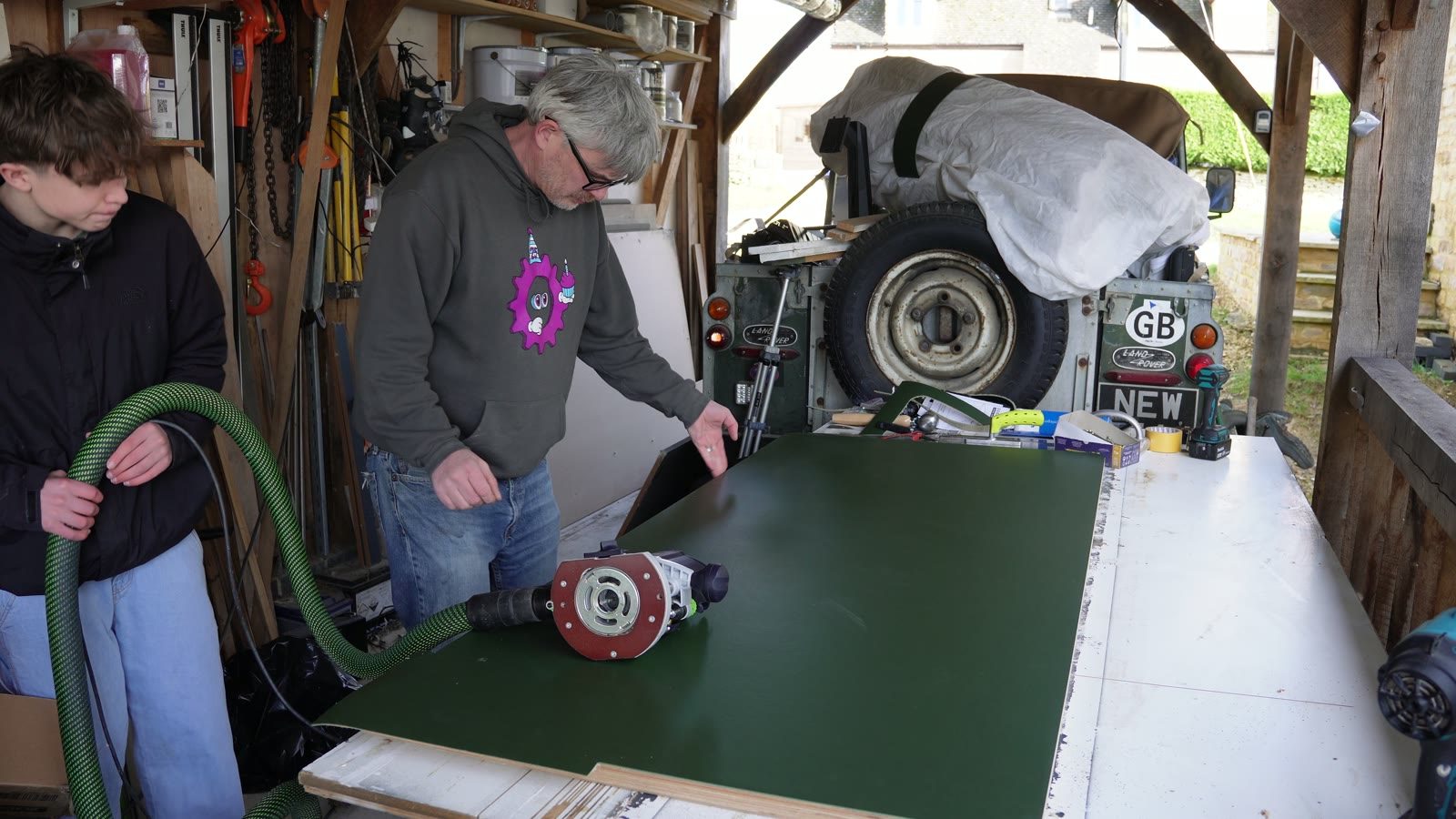 Daniel and his son test fitting the desk top against the lifting frame.