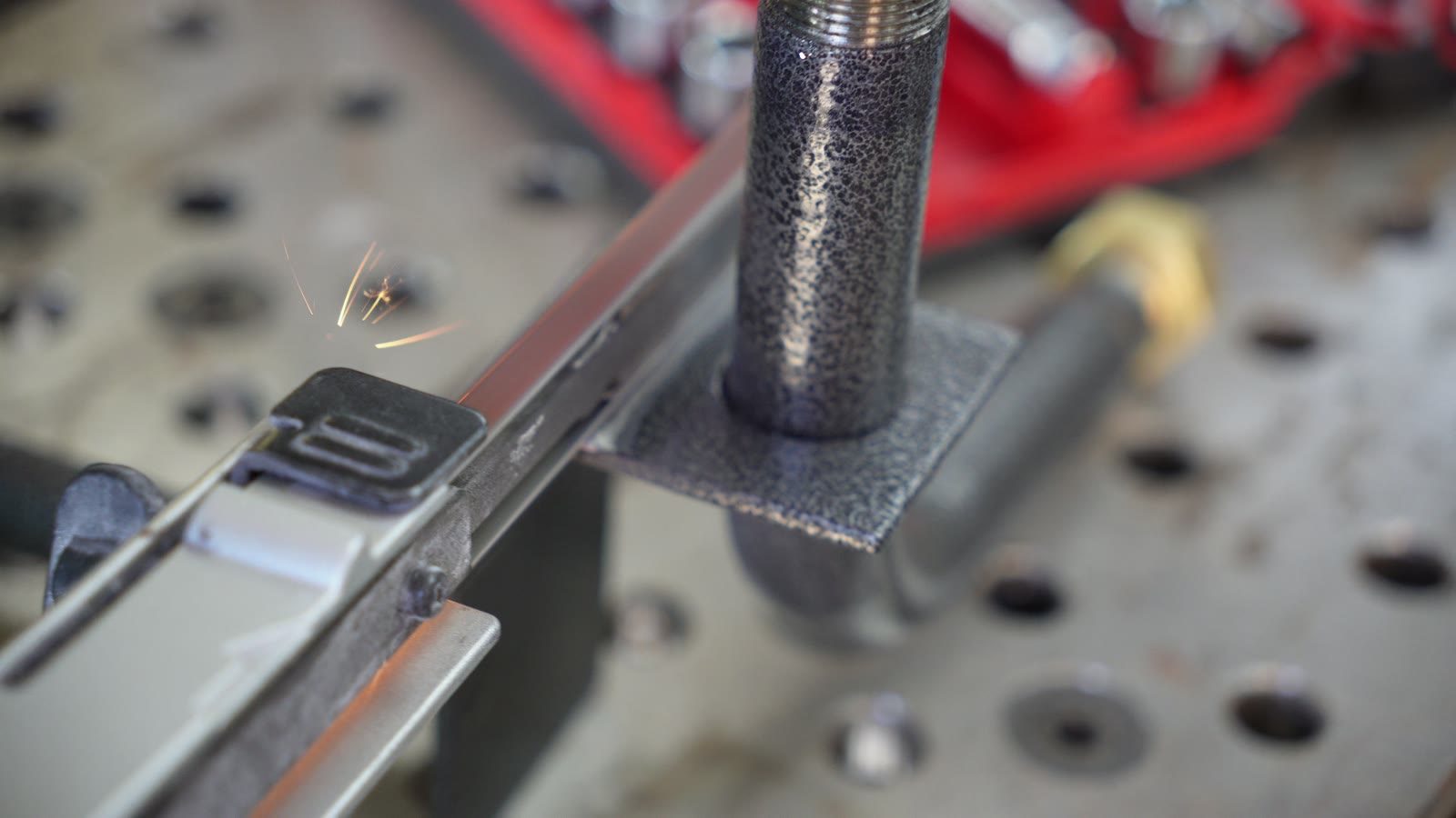 Close view of a robot arm part clamped on a workbench.