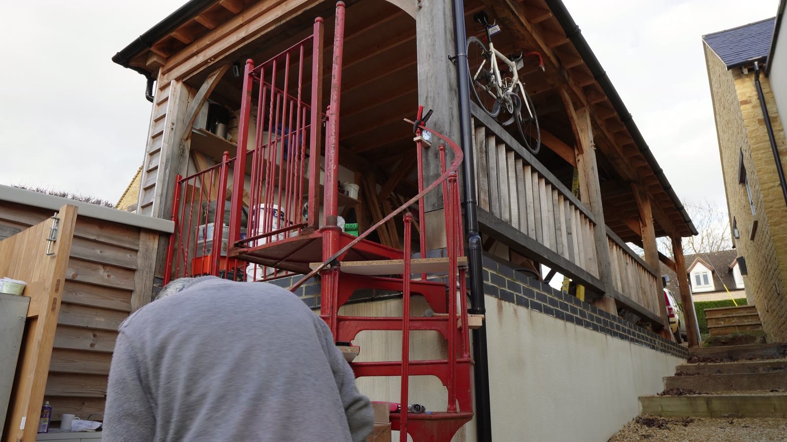 A red spiral staircase tread assembly being checked during the build.