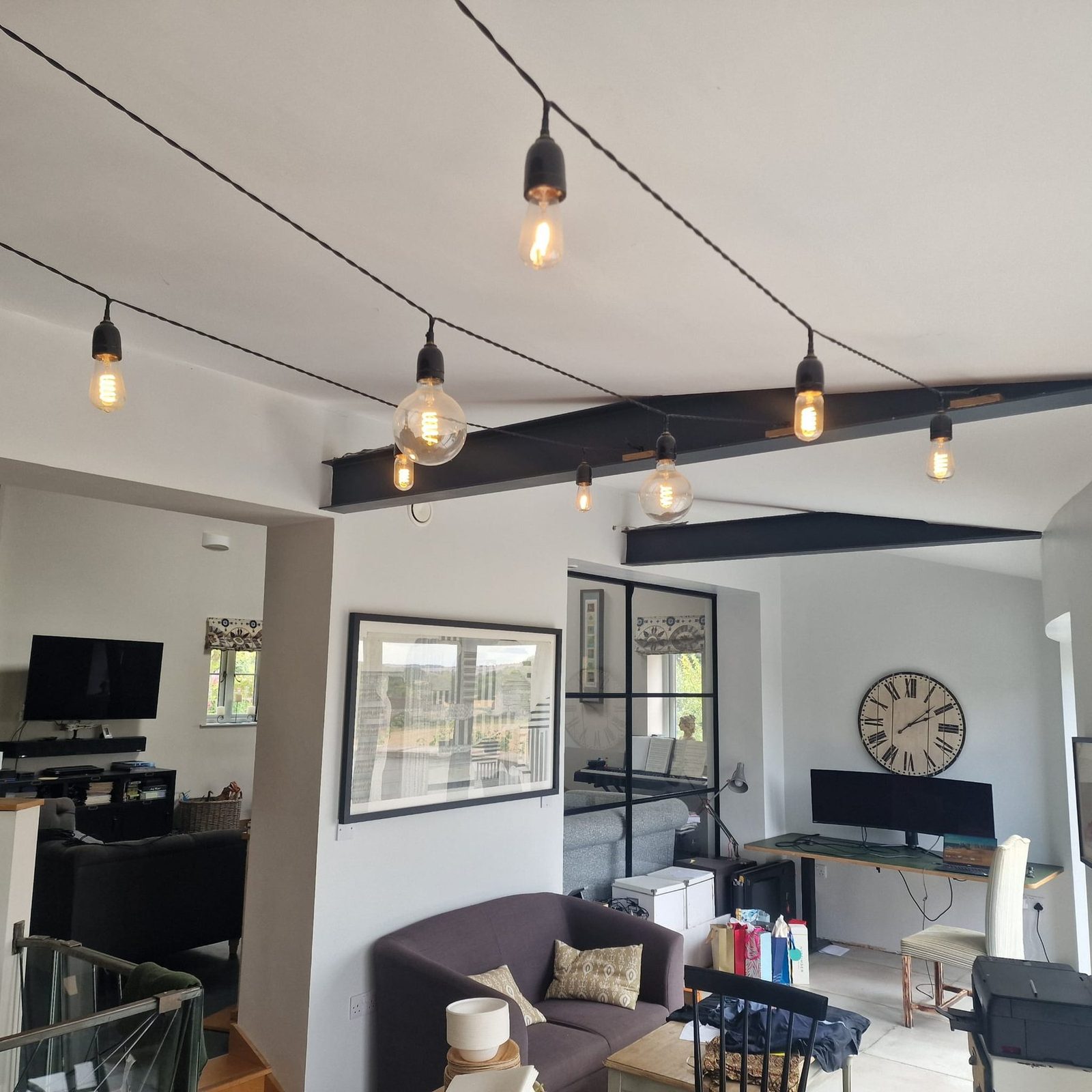 Finished vintage string lights hanging across ceiling beams.