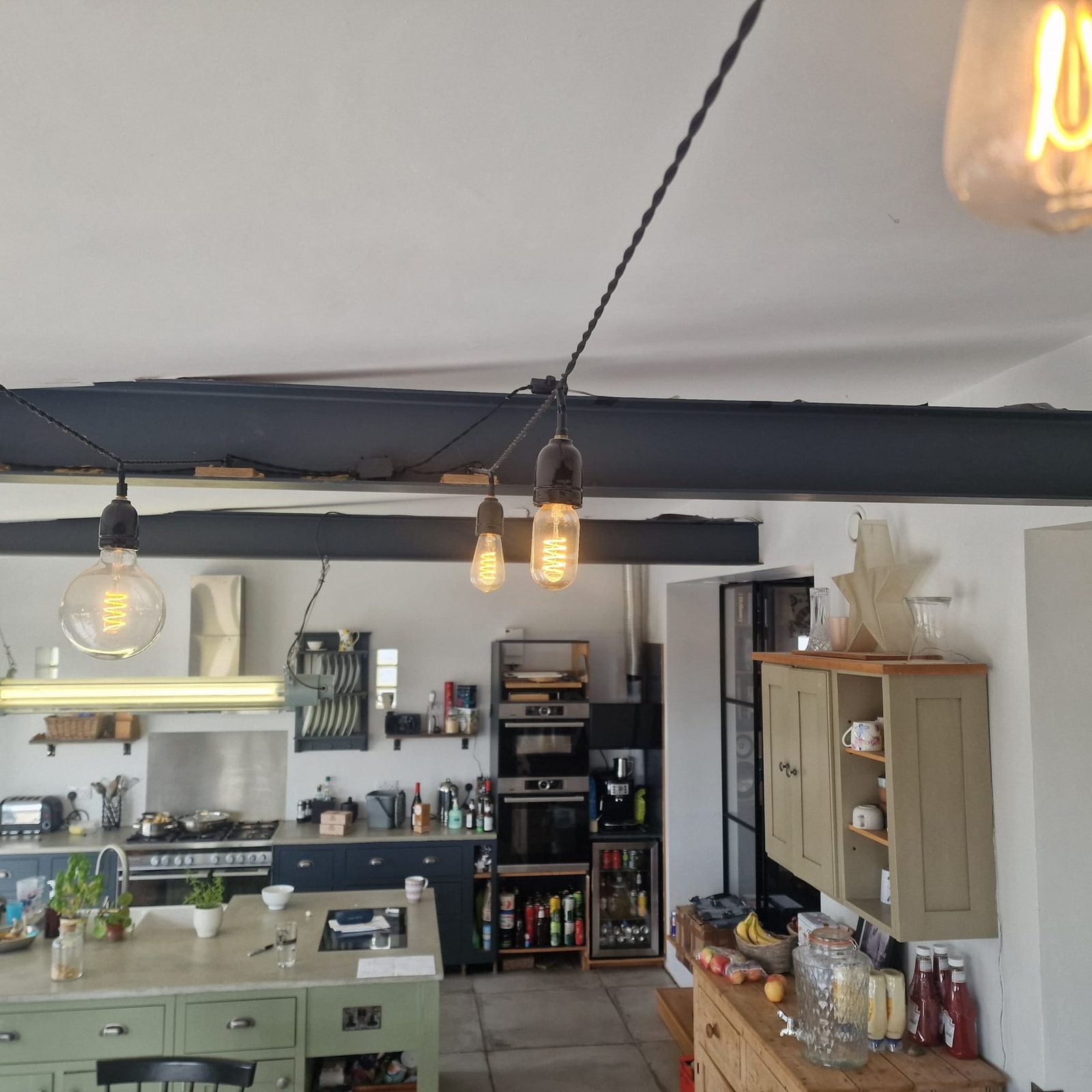 Vintage filament bulbs hanging above a kitchen area.