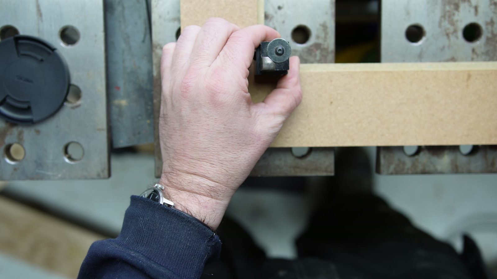 Marking wooden blocks on a metal work table.