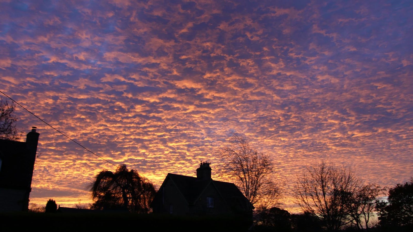 A dramatic orange and purple evening sky outside after the lighting project.